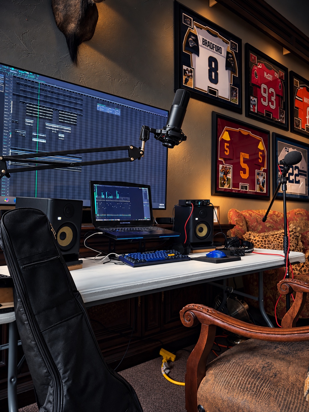 Full recording desk at OUTONSPACE Studios with monitors, microphone, and sports memorabilia